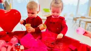 Dziewczynka i chłopiec tworzy ozdoby walentynkowe.